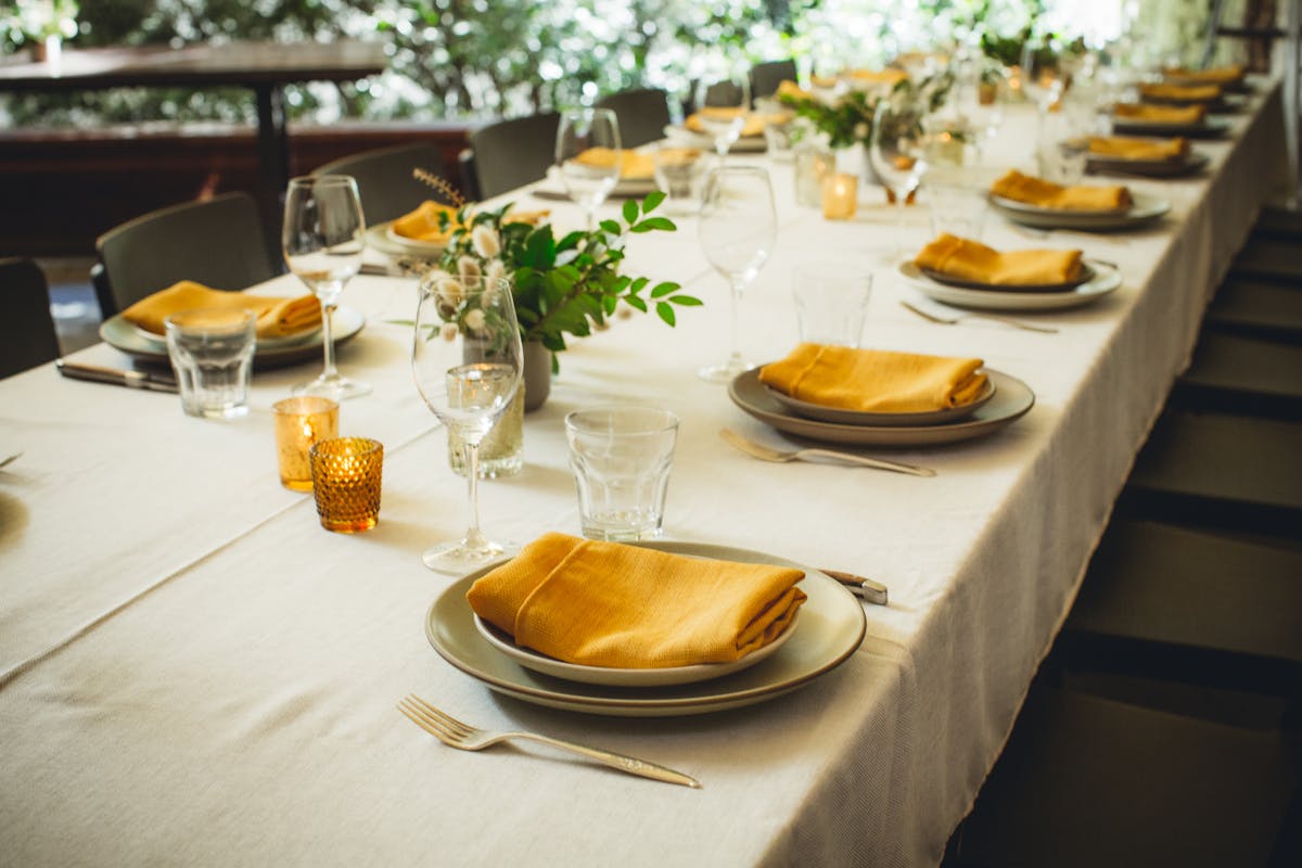 a large dinner table with the plates set 